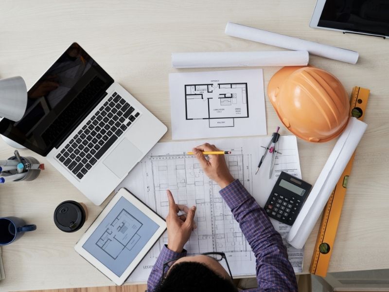 Civil engineer reviewing site plans, construction drawings, and project requirements before beginning the design process