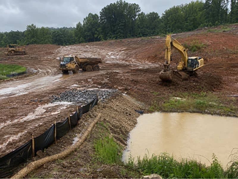 ESC plan timing for wet season earthwork at a construction site in Pensacola Florida showing erosion control measures and muddy grading conditions